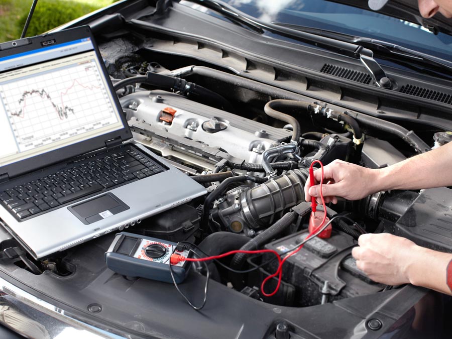 Vehicle technician with computer testing engine diagnostics